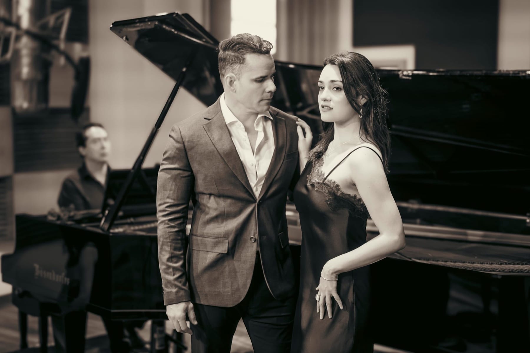 Lina de la Peña and Edward Salles beside a grand piano, in sepia